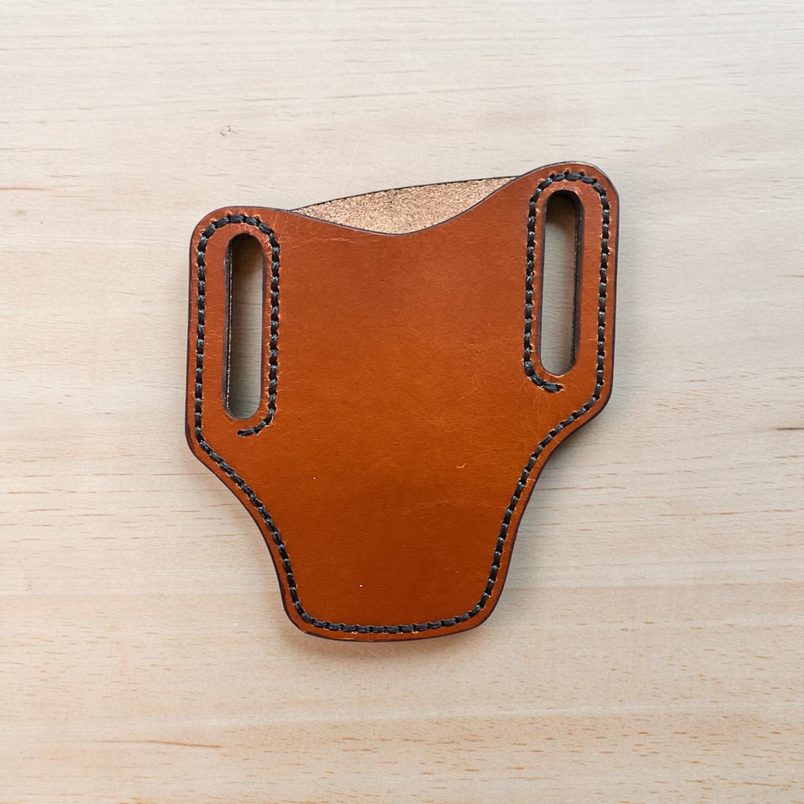 Angle belt style pancake pocket knife sheath. Saddle tan with black thread. Made from top grain leather.